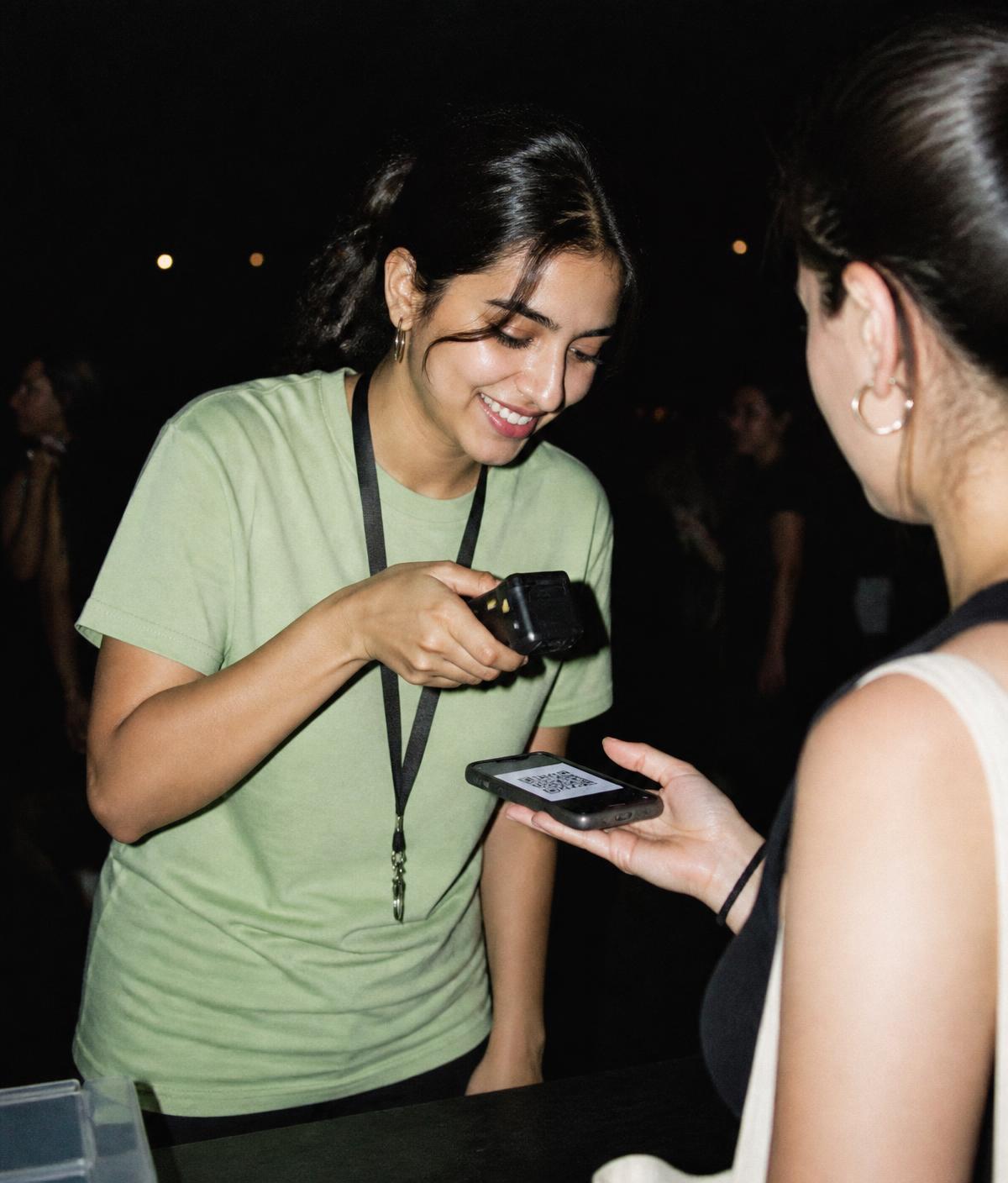 A volunteer scanning an attendee's ticket at the entry desk